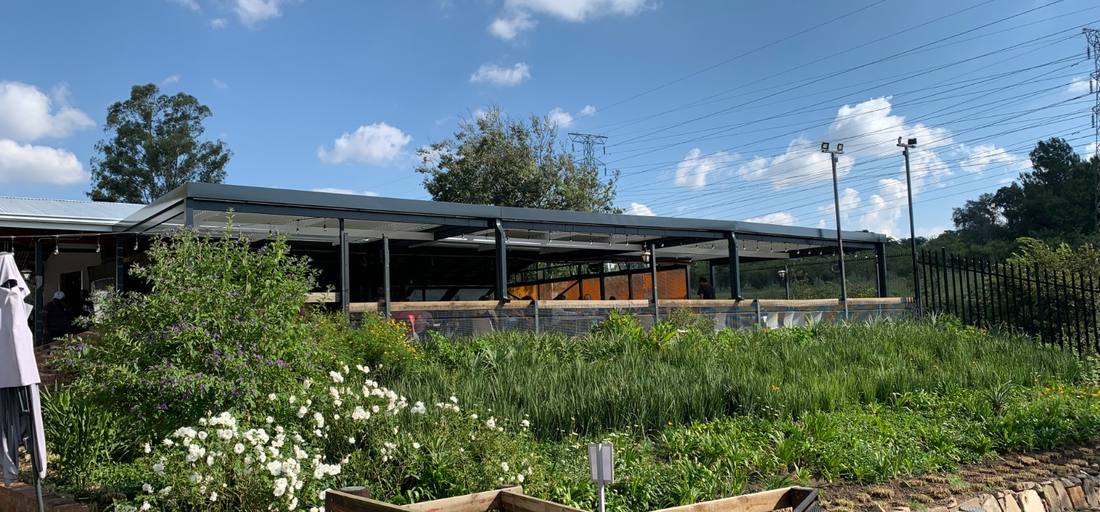 Charcoal louvre structure spanning an outdoor restaurant terrace