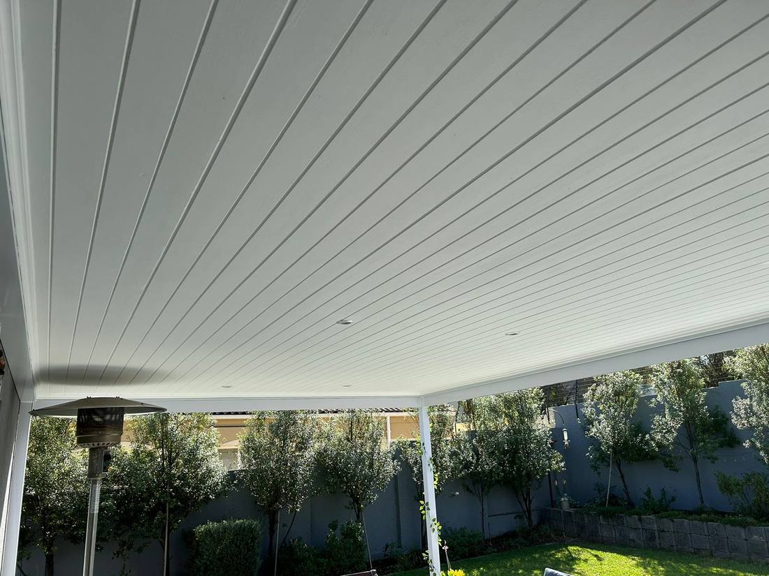 The grooved ceiling panel line running out to the front fascia
