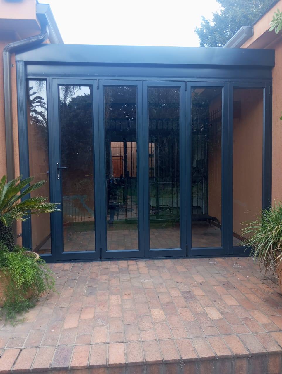 Aluminium stack folding doors closing the Kew patio