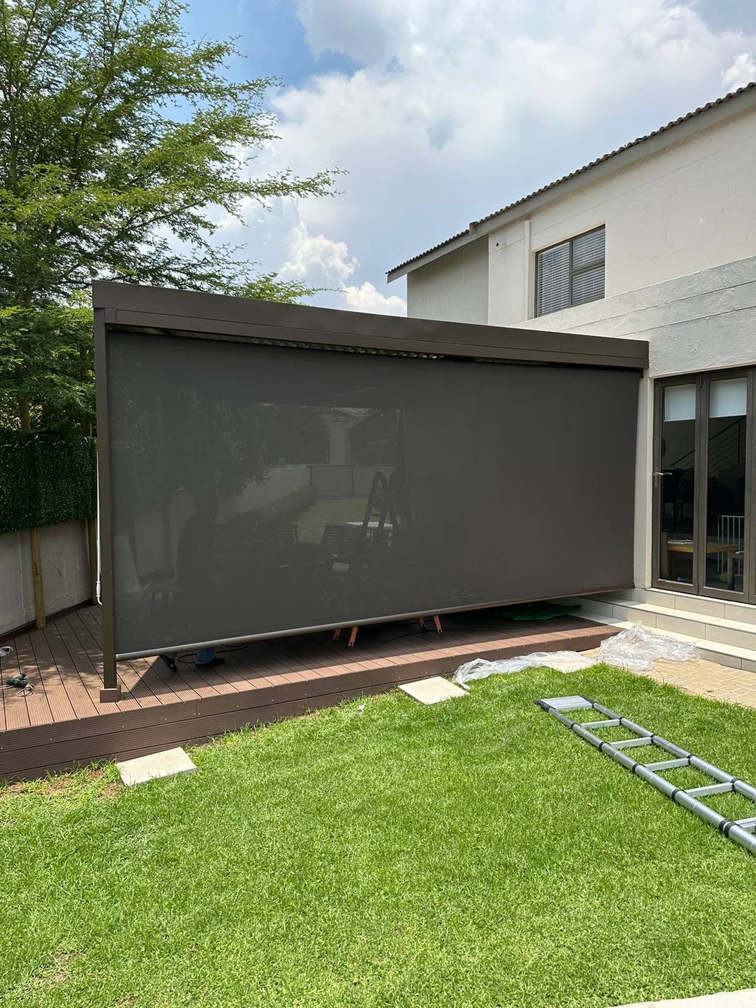 Drop blinds closing a patio to the garden side